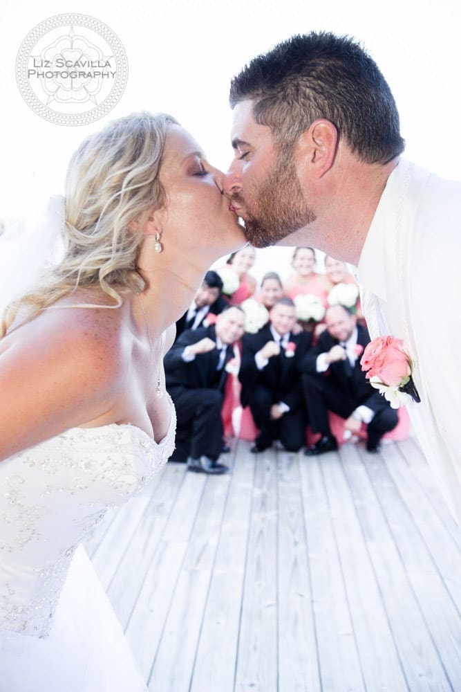 Wedding Party Behind Kissing Couple