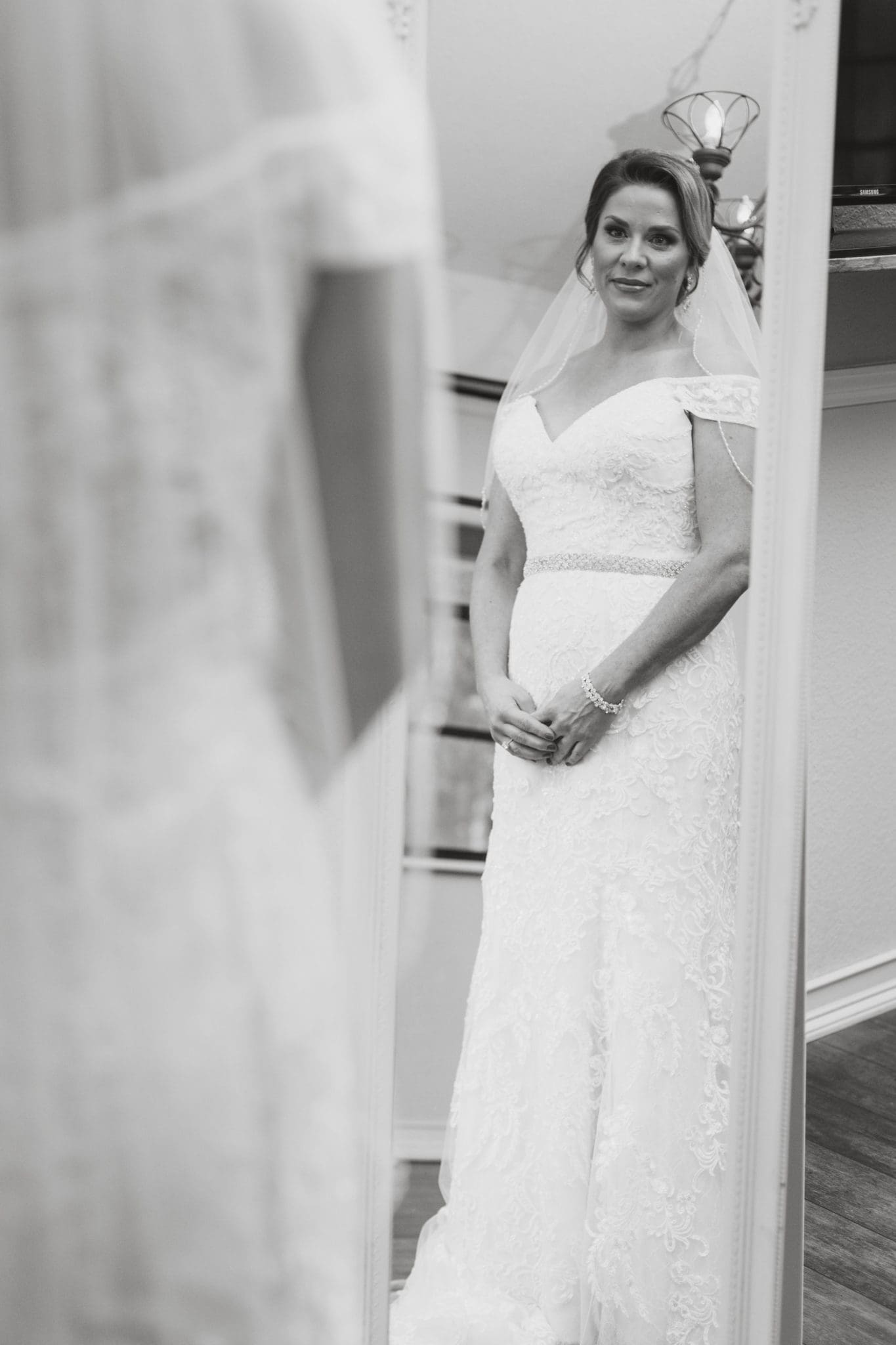 Bride looking at her reflection in the mirror.
