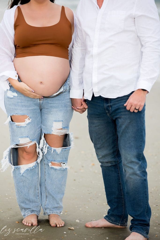 Close up maternity portrait showing baby bump and hands during a maternity photography session