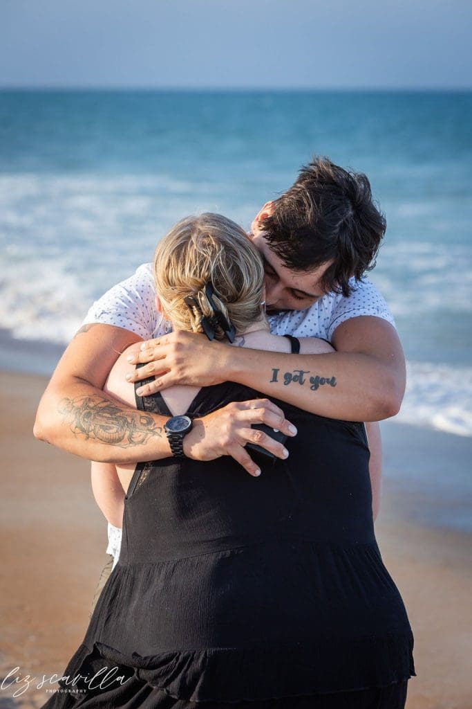 couple hugging after proposal beach emotional candid moment